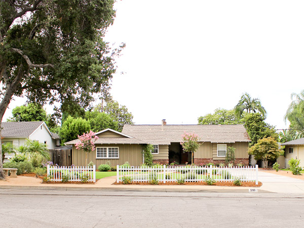 Home with white fence and trees